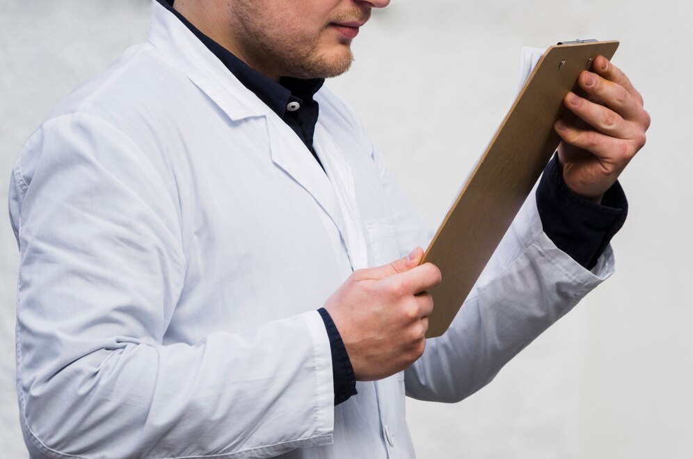 male-doctor-s-hand-reading-medical-report-clipboard