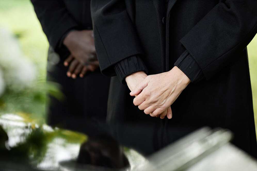 person-black-standing-by-coffin-outdoor-funeral-ceremony